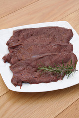 fette di fegato con rosmarino su piatto