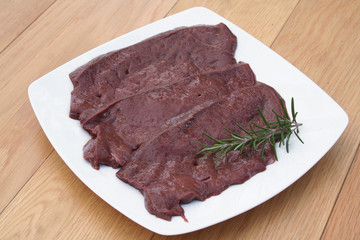 fette di fegato con rosmarino su piatto