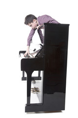 teenage boy and upright black piano in studio