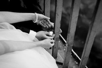 Newlyweds fix the lock on the bridge as a symbol of love