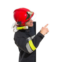 Smiling fireman in red helmet pointing at the blank banner