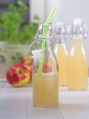 Apfelsaft in einer Flasche mit einem Strohhalm