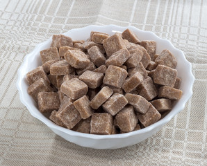brown refined sugar in a white cup