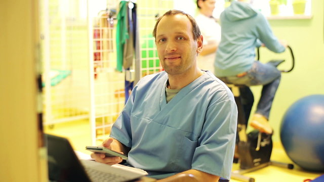 Portrait of happy, smiling doctor in rehabilitation room