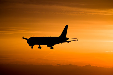 Fototapeta na wymiar Airplane landing at sunset, Frankfurt, Germany