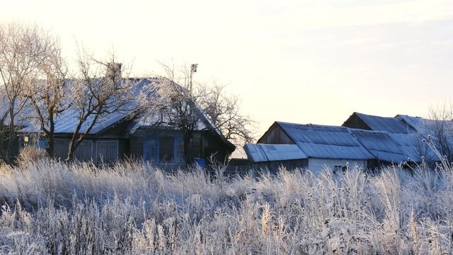 Village huts with smoke chimneys in the frosty morning