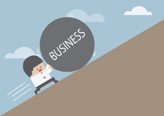 Businessman rolling ball with message 'BUSINESS' up on hill