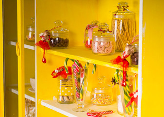 Candies on Glass Jars at Yellow Shelves