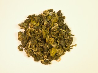 Small pile of green loose tea green snail isolated on white