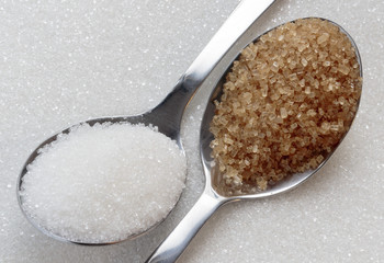 White and brown sugar on spoons