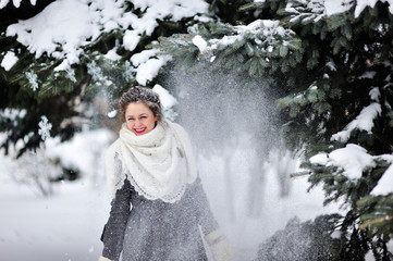 beautiful girl in winter throws snow