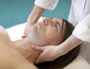 Fototapeta na wymiar Man receiving massage relax treatment close-up from female hands