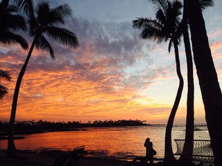 man taking a photo at sunset on the Island of Hawaii