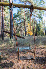 Fototapeta na wymiar rusty swing in holiday resort Izumrudnoe in Chernobyl Zone