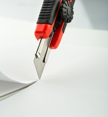 Red office knife isolated on white - obrazy, fototapety, plakaty