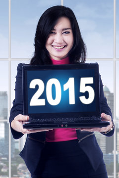 Pretty woman with numbers 2015 on laptop