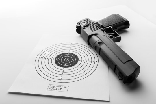 Paper target and pistol on white