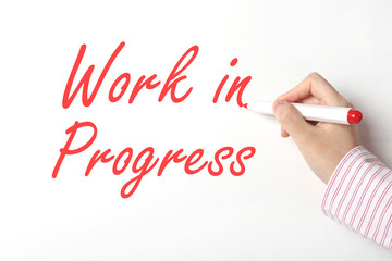 Writing work in progress word on whiteboard