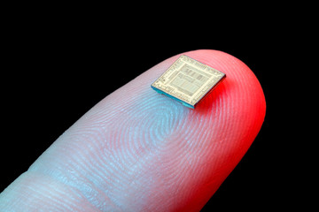 Silicon microchip on fingertip - obrazy, fototapety, plakaty
