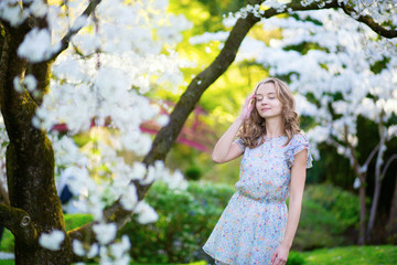 Beautiful girl in cherry blossom garden