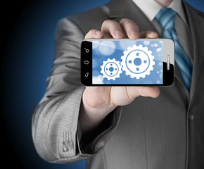 businessman show gear on smartphone to success concept