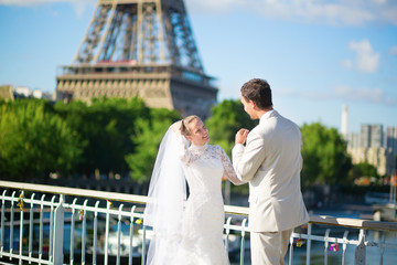 Fototapeta premium Just married couple in Paris near the Eiffel tower
