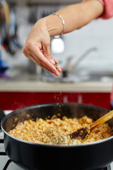Pouring pepper in a pan