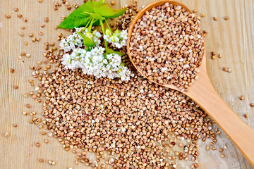 Buckwheat on board with flower and spoon