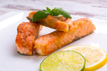 Salmon steak with lemon and lime on the plate