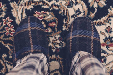 Man feet at home in pajamas and winter slippers - 75527695