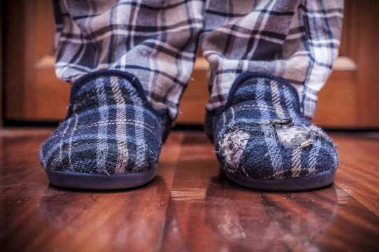 Man Feet At Home With Broken Slippers. Poverty