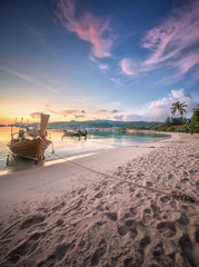 Naklejka premium sunset with colorful sky and boat on the beach