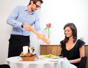 Beautiful young lady and waiter in restaurant