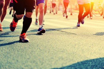 marathon athletes legs running on city road