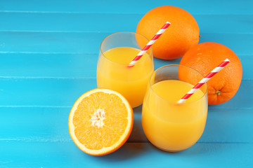 Glass of orange juice with straws and slices