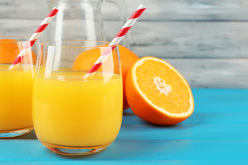 Glass of orange juice with straws and slices