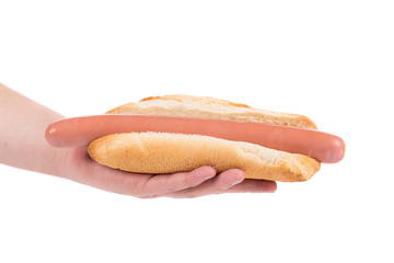 Hand holding hot dog bread and sausage.