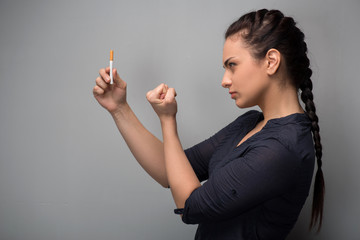 Addiction. Closeup of young woman determined girl holding cigare