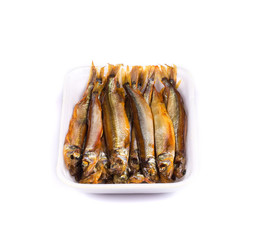 Smoke-dried anchovies in plate close up.