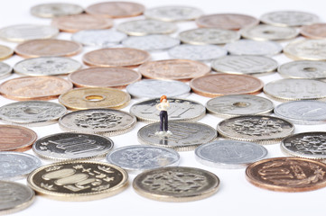 たくさん敷き詰められた日本円硬貨の上に立っている人間