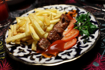 Veal kebab with tomatoes and fried potatoes