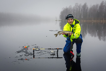 Men fishing pikes on ice