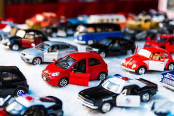 Many small toy cars lined up on the beautiful white fabric.