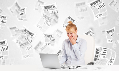 Business woman at desk with stock market newspapers