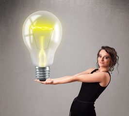 Beautiful lady holding realistic 3d light bulb