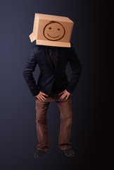 Young man gesturing with a cardboard box on his head with smiley
