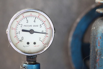 Close up pressure gauge with compressor.
