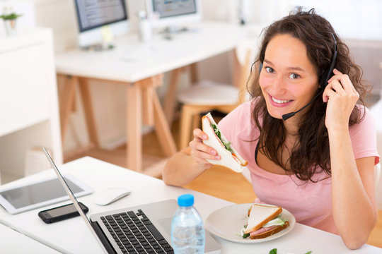 Young Attractive Student  Eating Sandwich While Working