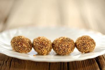 Homemade almond candies in row on white plate