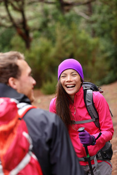 Couple having fun laughing hiking in forest